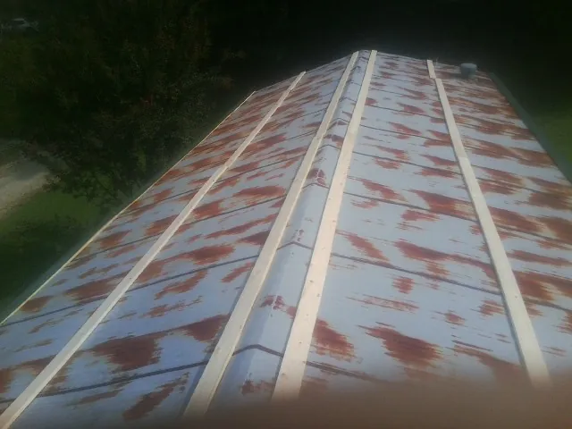 Rusted metal roof panels with new wood purlins before replacement — Storm Damage Roof Repair in Ennis by Roofing Brothers